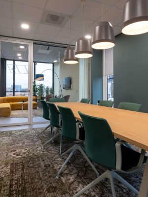 Several chairs put next to a table in a room with a patterned carpet